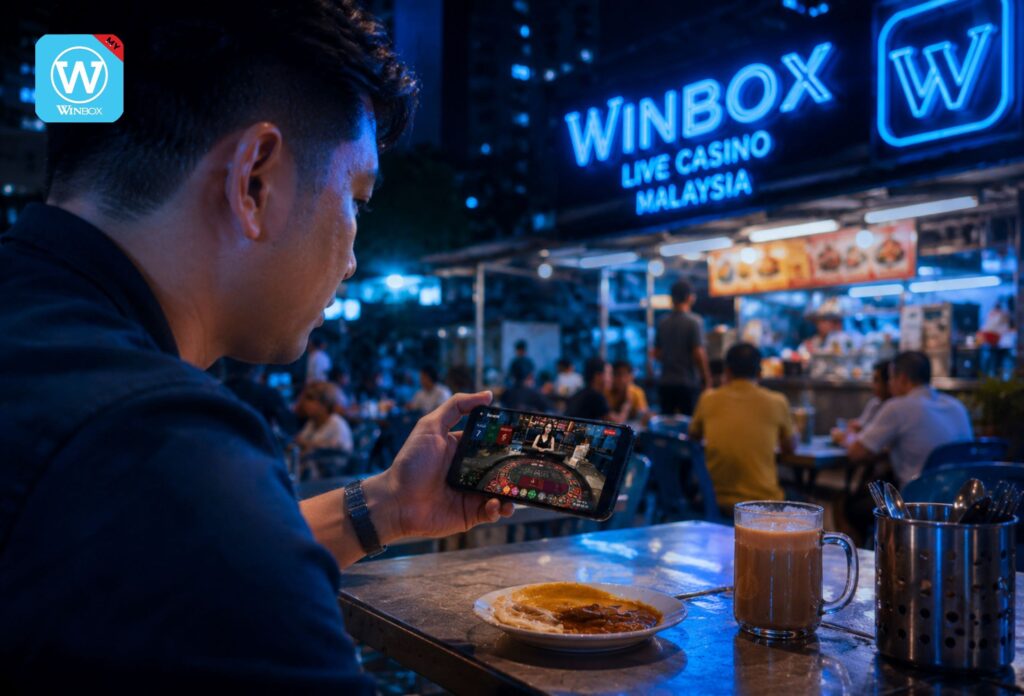 Malaysian player enjoying live roulette on Winbox mobile casino at mamak stall at night